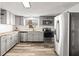 Well-equipped kitchen with stainless steel appliances, stone countertops and soft-grey cabinets at 9216 Mark Twain Ln, Port Richey, FL 34668