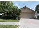 Charming single-story home featuring a brick driveway, mature landscaping, and an attached two-car garage at 8609 Thimbleberry Ln, Tampa, FL 33635