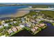 Stunning aerial view of a waterfront home with a pool, beautiful landscaping, and lake views at 1002 Romano Ne Ct, St Petersburg, FL 33702