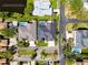Aerial view of home featuring a screened pool, solar panels, and well-manicured lawn with property boundaries at 1002 Romano Ne Ct, St Petersburg, FL 33702