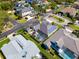 Beautiful aerial view of home with pool, screened lanai, solar panels, and lush green landscaping at 1002 Romano Ne Ct, St Petersburg, FL 33702