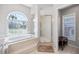 Bright bathroom featuring a soaking tub, shower, and shuttered window at 1002 Romano Ne Ct, St Petersburg, FL 33702