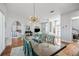 Dining room with chandelier, a large table, and an open view to the entryway and living room at 1002 Romano Ne Ct, St Petersburg, FL 33702