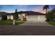 Elegant home exterior with a dark roof, a three car garage, and professionally landscaped front yard at 1002 Romano Ne Ct, St Petersburg, FL 33702