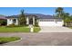 Stunning single-story home features a three-car garage, manicured lawn, and contemporary architectural details at 1002 Romano Ne Ct, St Petersburg, FL 33702