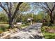 Gated community entrance with guard house and stop sign framed by mature trees and beautiful landscaping at 1002 Romano Ne Ct, St Petersburg, FL 33702