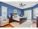 Main bedroom featuring hardwood floors, shuttered windows, accent wall, and a ceiling fan at 1002 Romano Ne Ct, St Petersburg, FL 33702