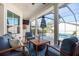 Covered patio area with comfortable seating, ceiling fan, and a view of the pool and backyard at 1002 Romano Ne Ct, St Petersburg, FL 33702