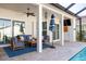 Relaxing screened patio with comfortable seating, ceiling fan, and stylish decor by the beautiful pool at 1002 Romano Ne Ct, St Petersburg, FL 33702
