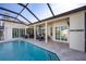 Outdoor pool area with a covered patio, outdoor kitchen, and a screened enclosure for year-round enjoyment at 1002 Romano Ne Ct, St Petersburg, FL 33702