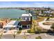 Aerial view of a modern two-story home with a balcony on a waterfront lot at 109 Punta Vista Dr, St Pete Beach, FL 33706