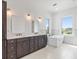 Bathroom featuring dual vanities, soaking tub, and outdoor views at 109 Punta Vista Dr, St Pete Beach, FL 33706