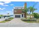 Beautiful two-story home with modern design, palm trees, a paved driveway, and manicured landscaping at 109 Punta Vista Dr, St Pete Beach, FL 33706