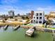 A modern three-story home featuring a dock, boat lift, and swimming pool, located on the water in a coastal community at 109 Punta Vista Dr, St Pete Beach, FL 33706