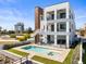 Backyard view featuring a pool with tanning ledge, outdoor kitchen, upper floor balconies, and modern three-story construction at 109 Punta Vista Dr, St Pete Beach, FL 33706
