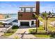 Waterfront modern two-story home featuring a balcony and a paved driveway at 109 Punta Vista Dr, St Pete Beach, FL 33706