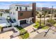 Modern two-story home featuring a balcony, a paved driveway, and tropical landscaping at 109 Punta Vista Dr, St Pete Beach, FL 33706