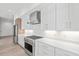 Modern kitchen features stainless steel appliances, white cabinetry and countertops, and a gas range at 109 Punta Vista Dr, St Pete Beach, FL 33706