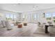 Bright living room with water views, modern furniture, hardwood floors, and an adjacent dining area at 109 Punta Vista Dr, St Pete Beach, FL 33706