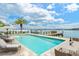 Luxurious waterfront pool with lounge chairs and dining area, set against a beautiful water backdrop at 109 Punta Vista Dr, St Pete Beach, FL 33706