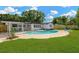 The backyard features a pool, a well-manicured lawn, and chairs, perfect for summer fun and relaxation at 11361 88Th Ave, Seminole, FL 33772