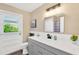 Bathroom features modern vanity, white countertops, new fixtures, and door to outside at 11361 88Th Ave, Seminole, FL 33772