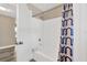 Bathroom with white tiled shower featuring white and blue patterned shower curtain at 11361 88Th Ave, Seminole, FL 33772