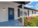 Inviting entryway with a stylish blue door, stone accents, and colorful landscaping at 11361 88Th Ave, Seminole, FL 33772