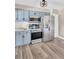 Close-up of stainless steel appliances, light blue cabinets and sleek countertops in modern kitchen at 11361 88Th Ave, Seminole, FL 33772