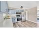 Bright kitchen with light blue cabinets, modern stainless steel appliances, and wood-look flooring at 11361 88Th Ave, Seminole, FL 33772