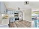 Modern kitchen featuring sleek stainless steel appliances, light blue cabinetry, and a view into living room at 11361 88Th Ave, Seminole, FL 33772