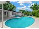 Backyard pool area features a sparkling pool, ample lounge space, and lush, mature landscaping at 11361 88Th Ave, Seminole, FL 33772
