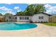 Backyard pool with a well-kept lawn and a house with a dark roof, offering a refreshing outdoor space at 11361 88Th Ave, Seminole, FL 33772