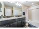 A bathroom with a double sink vanity, granite countertop, and shower-tub combination at 11602 Crowned Sparrow Ln, Tampa, FL 33626