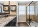 Well-appointed bathroom featuring granite countertops, dark cabinetry, and a glass enclosed shower at 11602 Crowned Sparrow Ln, Tampa, FL 33626