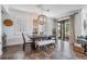 Sunlit dining room featuring modern lighting, large windows, and a neutral color palette at 11602 Crowned Sparrow Ln, Tampa, FL 33626