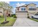 Charming tan two-story townhome featuring a spacious two-car garage and manicured lawn at 11602 Crowned Sparrow Ln, Tampa, FL 33626
