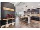 Open kitchen featuring a large island with pendant lighting, dark cabinets, and an open floorplan at 11602 Crowned Sparrow Ln, Tampa, FL 33626
