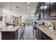 Modern kitchen featuring dark cabinetry, granite countertops, stainless steel appliances at 11602 Crowned Sparrow Ln, Tampa, FL 33626