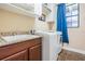 Functional laundry room with a utility sink, ample counter space, and a front load washer at 11602 Crowned Sparrow Ln, Tampa, FL 33626