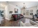A modern living room featuring hardwood floors, updated light fixture, and a brown leather sofa at 11602 Crowned Sparrow Ln, Tampa, FL 33626