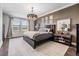 Main bedroom with hardwood floors, a large window, and designer inspired furnishings at 11602 Crowned Sparrow Ln, Tampa, FL 33626