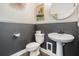 Chic powder room featuring two-tone walls, modern fixtures and a pedestal sink at 11602 Crowned Sparrow Ln, Tampa, FL 33626