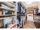 Organized walk-in closet with custom shelving for shoes, accessories, and hanging storage at 11602 Crowned Sparrow Ln, Tampa, FL 33626