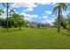 Expansive backyard featuring a lush lawn, mature trees, and a screened-in porch at 12006 Glenshire Dr, Riverview, FL 33579