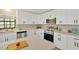 Modern kitchen featuring sleek white cabinets, stainless steel appliances, and quartz countertops at 12006 Glenshire Dr, Riverview, FL 33579
