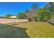 Expansive backyard with lush green grass, a white fence, and a playset for outdoor fun at 1218 Halapa Way, Trinity, FL 34655