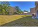Spacious backyard with lush green grass, mature trees, and a white fence for privacy at 1218 Halapa Way, Trinity, FL 34655