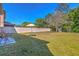 Beautiful, fenced backyard featuring lush grass, mature trees, and outdoor seating area at 1218 Halapa Way, Trinity, FL 34655