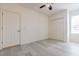 Open bedroom with wood-look floors, ceiling fan and double closet doors for storage at 1218 Halapa Way, Trinity, FL 34655